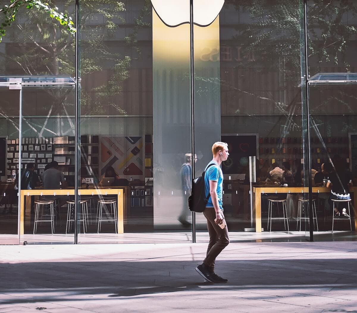 Man walking in front of an Apple building