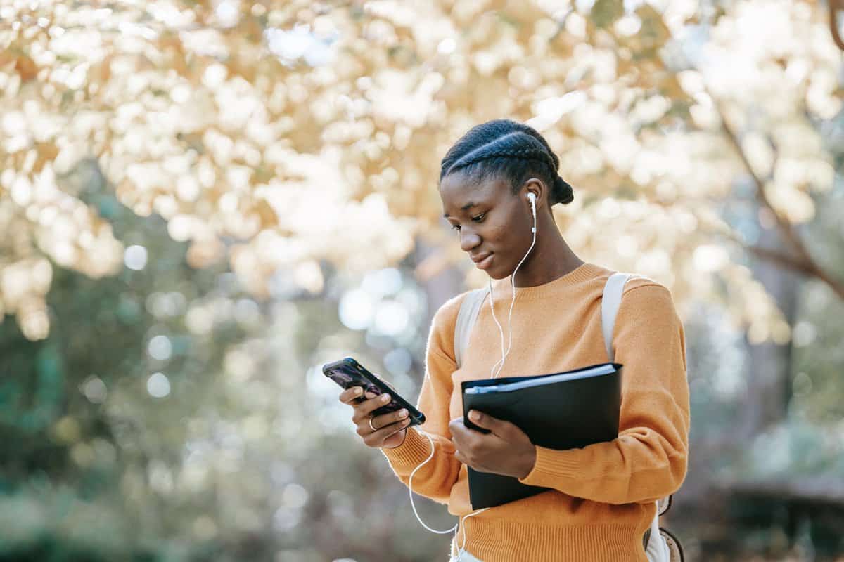 woman in orange sweater looking at phone
